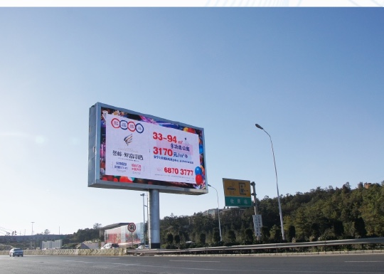 Outdoor roadside LED billboard in a highway setting